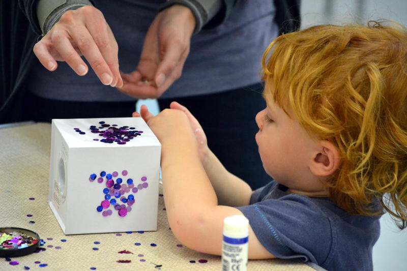 Small fingers decorating a money box