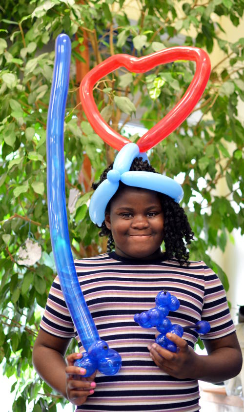 Carrying and wearing a selection of balloon models