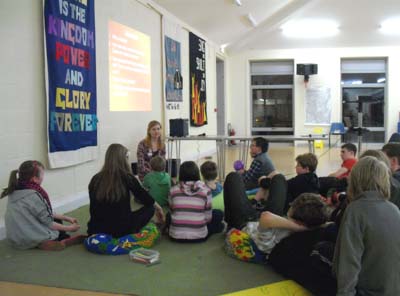 Young people sitting on the floor taking part in a discussion